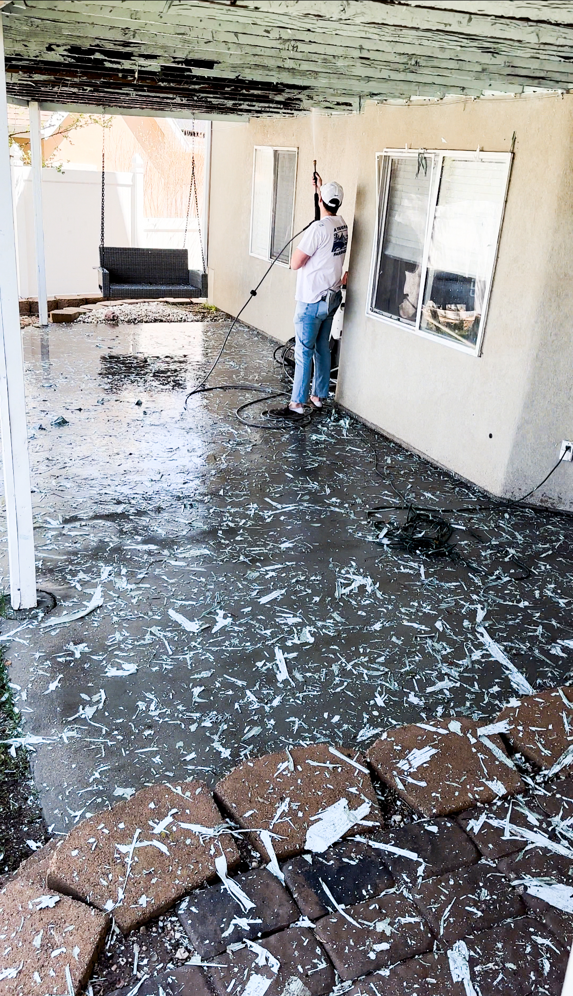 man holding a power washer with paint chips all over the deck